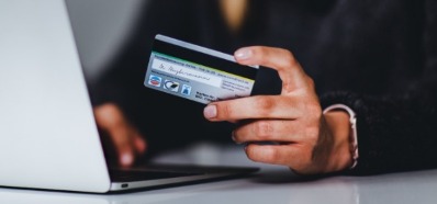 Woman holding her credit card while on the computer