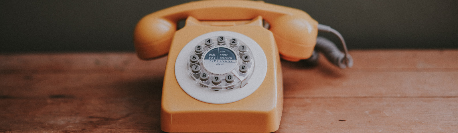 Old rotary phone sitting on desk