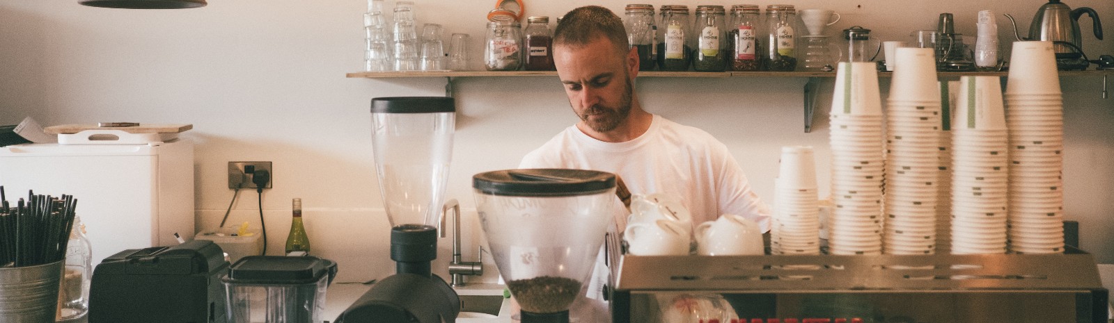 Barista working behind a coffee shop counter